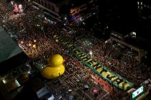 Demonstrators look on at a big screen showing a session to review the request for Brazilian President Dilma Rousseff's impeachment in Brasilia, during a protest against her at Paulista Avenue in Sao Paulo, Brazil, April 17, 2016. PHOTO BY REUTERS/Rodrigo Paiva