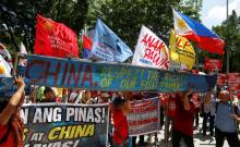 Demonstrators display a part of a fishing boat with anti-China protest signs during a rally by different activist groups over the South China Sea disputes, outside the Chinese Consulate in Makati City, Metro Manila, Philippines, July 12, 2016. PHOTO BY REUTERS/Erik De Castrby