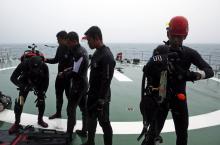 A group of divers prepares their gear on the deck of the Search and Rescue (SAR) ship KN Purworejo during a search operation for passengers onboard AirAsia Flight QZ8501 in the Java Sea, January 4, 2015. PHOTO BY REUTERS/Beawiharta