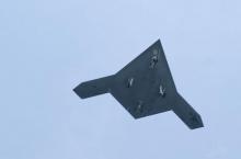 An X-47B pilot-less drone combat aircraft flies over the deck of the USS George H.W. Bush aircraft carrier in the Atlantic Ocean off the coast of Norfolk, Virginia, July 10, 2013. PHOTO BY REUTERS/Rich-Joseph Facun