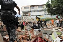 Red Cross members, military and police officers work at a collapsed area after an earthquake struck off Ecuador's Pacific coast, at Tarqui neighborhood in Manta, April 17, 2016. PHOTO BY REUTERS/Guillermo Granja