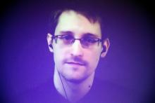 Former U.S. National Security Agency contractor Edward Snowden, who is in Moscow, is seen on a giant screen during a live video conference for an interview as part of Amnesty International's annual Write for Rights campaign at the Gaite Lyrique in Paris, December 10, 2014. PHOTO BY REUTERS/Charles Platiau