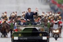 French President Emmanuel Macron waves as stands in the military command car on the Champs-Elysees to attend a ceremony at the Tomb of the Unknown soldier at the Arc de Triomphe in Paris, France, May 14, 2017. PHOTO BY REUTERS/Michel Euler