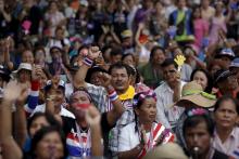 Anti-government protesters react as they listen to a leader's speech at an intersection protesters are occupying in downtown Bangkok