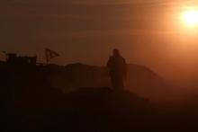 A Syrian Democratic Forces (SDF) fighter stands near a flag in northern Raqqa province, Syria, February 6, 2017. PHOTO BY REUTERS/Rodi Said