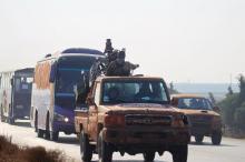 Fighters from a coalition of rebel groups called "Jaish al Fateh", also known as "Army of Fatah" (Conquest Army), escort buses evacuating fighters and civilians from the two besieged Shi'ite towns of al-Foua and Kefraya in the mainly rebel-held northwestern province of Idlib, Syria, December 28, 2015. PHOTO BY REUTERS/Ammar Abdullah