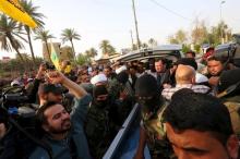 Fighters of Shiite militia group Kataib Hezbollah, with people prepare to deliver the body of a man believed to be Ezzat al-Douri, to the Iraqi government in Baghdad, April 20, 2015. PHOTO BY REUTERS/Stringer
