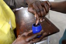 A voter's finger is marked after voting in the general election in Maputo