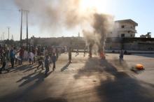 People gather near burning tyres during a demonstration against forces loyal to Syria's President Bashar al-Assad and calling for aid to reach Aleppo near Castello road in Aleppo, Syria, September 14, 2016. PHOTO BY REUTERS/Abdalrhman Ismail