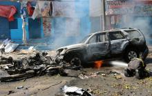 A firefighter tries to extinguish fire from the wreckage of a burning vehicle following an attack on a restaurant by the Somali Islamist group al Shabaab in the capital Mogadishu, Somalia, October 1, 2016. PHOTO BY REUTERS/Feisal Omar