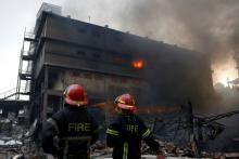 Firefighters stand at the site of a fire at a packaging factory outside Dhaka, Bangladesh, September 10, 2016. PHOTO BY REUTERS/Mohammad Ponir Hossain