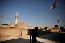 A man makes his way as a Kurdish flag flutters atop the Citadel of Erbil, northern Iraq, June 8, 2017. PHOTO BY REUTERS/Alkis Konstantinidis