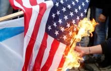 A Palestinian demonstrator burns a U.S. flag during a protest against the U.S. intention to move its embassy to Jerusalem and to recognize the city of Jerusalem as the capital of Israel, in Gaza City, December 6, 2017. PHOTO BY REUTERS/Mohammed Salem