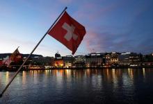 A Swiss flag is pictured during the sunrise on the Commercial and Financial District in Geneva, Switzerland, November 23, 2017. PHOTO BY REUTERS/Denis Balibouse