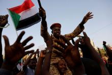 A Sudanese soldier sits on the shoulders of a demonstrator, cheering with the crowd outside Defence Ministry in Khartoum, Sudan, April 16, 2019. PHOTO BY REUTERS/Umit Bektas