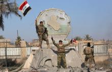 A member of the Iraqi security forces holds an Iraqi flag at a government complex in the city of Ramadi, December 28, 2015. PHOTO BY REUTERS/Stringer