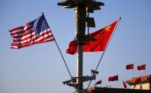 U.S. (L) and Chinese national flags flutter on a light post at the Tiananmen Square ahead of a welcoming ceremony for U.S. President Barack Obama, in Beijing, November 12, 2014. PHOTO BY REUTERS/Petar Kujundzic