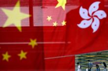 People walk past Chinese and Hong Kong flags after celebrations commemorating the 20th anniversary of Hong Kong's handover to Chinese sovereignty from British rule, in Hong Kong, China, July 2, 2017. PHOTO BY REUTERS/Tyrone Siu