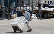 A Palestinian man pushes a cart with bags of flour at an aid distribution center run by United Nations Relief and Works Agency (UNRWA) in Khan Younis in the southern Gaza Strip, September 1, 2018. PHOTO BY REUTERS/Ibraheem Abu Mustafa