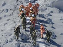 Japan Self-Defense Force (JSDF) soldiers and firefighters carry an injured person near a crater of Mt. Ontake, which straddles Nagano and Gifu prefectures