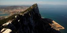 The Spanish city of La Linea de la Concepcion (rear), and the top of the Rock, a monolithic limestone promontory, are seen next to the construction (R) of Cape Vantage, in the British overseas territory of Gibraltar, south of Spain August 16, 2013. REUTERS/Jon Nazca/File Photo