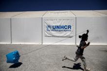 A girl plays with a plastic bag as she runs past a United Nations High Commissioner for Refugees (UNHCR) tent, at a camp for refugees and migrants in Schisto, near Athens, Greece, April 26, 2016. PHOTO BY REUTERS/Alkis Konstantinidis