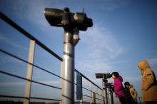A girl looks toward the North through a pair of binoculars near the demilitarized zone separating the two Koreas in Paju, South Korea, January 3, 2018. PHOTO BY REUTERS/Kim Hong-Ji