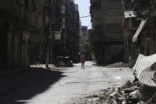 A girl stands in a damaged street in Ain Tarma, in Eastern Ghouta, a suburb of Damascus