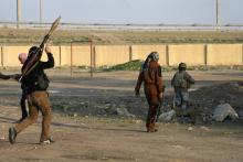 Masked Sunni Muslim gunmen take up positions with their weapons during a patrol in the city of Falluja, 70 km (44 miles) west of Baghdad