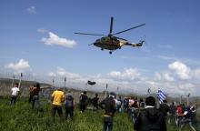 Migrants and refugees react as a Macedonian police helicopter flies over during clashes next to a border fence at a makeshift camp at the Greek-Macedonian border near the village of Idomeni, Greece, April 10, 2016. PHOTO BY REUTERS/Stoyan Nenov