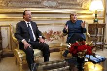 French President Francois Hollande and German Chancellor Angela Merkel (R) meet in President's office prior to a dinner at the Elysee Palace, in Paris