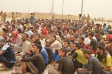 Displaced people, who fled from Falluja because of Islamic State violence, wait for security checks from Iraqi security forces during a dust storm on the outskirts of Falluja, Iraq, June 18, 2016. PHOTO BY REUTERS/Stringer