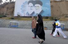 Iranians walk past a large picture of Iran's late leader Ayatollah Ruhollah Khomeini (L), and Iran's Supreme Leader Ayatollah Ali Khamenei at a park in Tehran, Iran, January 17, 2016. PHOTO BY REUTERS/Raheb Homavandi/TIMA