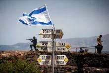 An Israeli soldier stands next to signs pointing out distances to different cities, on Mount Bental, an observation post in the Israeli-occupied Golan Heights that overlooks the Syrian side of the Quneitra crossing, Israel, May 10, 2018. PHOTO BY REUTERS/Ronen Zvulun