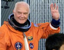 Astronaut John Glenn waves with crewmates as they depart crew quarters for the launching pad at the Kennedy Space Centre October 29, 1998. PHOTO BY REUTERS