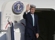U.S. Secretary of State John Kerry waves as he steps aboard his aircraft in Sydney