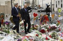 U.S. Secretary of State John Kerry (L) walks with French Foreign Minister Laurent Fabius through a memorial at the site of an attack at the Charlie Hebdo newspaper in Paris January 16, 2015. PHOTO BY REUTERS/Rick Wilking