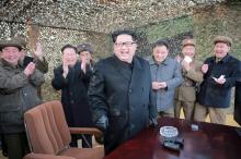 North Korean leader Kim Jong Un (C) smiles as he guides a test fire of a new multiple launch rocket system in this undated photo released by North Korea's Korean Central News Agency (KCNA) in Pyongyang, March 4, 2016. PHOTO BY REUTERS/KCNA