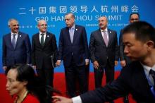 A security agent reacts as a woman tries to have a pictures taken in front of Turkey's President Tayyip Erdogan (C) and his delegation after the closing of G20 Summit in Hangzhou, Zhejiang Province, China, September 5, 2016. PHOTO BY REUTERS/Damir Sagolj