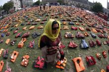 Rehab Sidiqi, a trustee of Woman for Refugee Woman and originally from Afghanistan, poses for a photograph among 2500 lifejackets worn by refugees during their crossing from Turkey to the Greek island of Chois, in Parliament Square in central London, Britain, September 19, 2016. PHOTO BY REUTERS/Stefan Wermuth