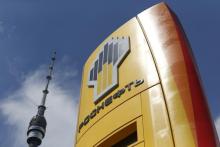 The logo of Russia's top crude producer Rosneft is seen on a price information board of a gasoline station, with the Ostankino television and radio tower seen in the background, in Moscow