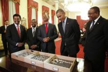 Dr. Zeresenay Alemseged Lemseged (C), of the California Academy of Sciences, laughs at a quip by U.S. President Barack Obama (2ndR) as he and Ethiopia's Prime Minister Hailemariam Desalegn (R) look at the bones of Lucy, an early human, before a State Dinner in Obama's honor at the National Palace in Addis Ababa, Ethiopia July 27, 2015. PHOTO BY REUTERS/Jonathan Ernst