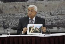 Palestinian President Mahmoud Abbas shows a picture of Palestinian minister Ziad Abu Ein as he is grabbed by an Israeli border policeman, during a meeting with the Palestinian leadership in the West Bank city of Ramallah, December 10, 2014. PHOTO BY REUTERS/Mohamad Torokman