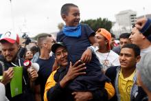 A man and his son, members of a caravan of migrants from Central America, react near the San Ysidro checkpoint as the first fellow migrants entered U.S. territory to seek asylum on Monday, in Tijuana, Mexico, April 30, 2018. PHOTO BY REUTERS/Edgard Garrido