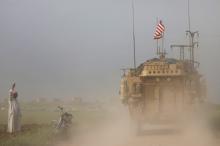 A man gestures at U.S military vehicles driving in the town of Darbasiya next to the Turkish border, Syria, April 28, 2017. PHOTO BY REUTERS/Rodi Said