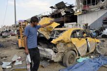 A man looks at damages at the site of a car bomb attack in Baghdad