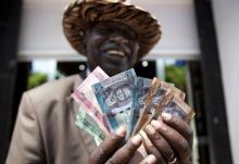 A man from South Sudan displays currency notes outside the Central Bank of South Sudan in Juba. PHOTO BY REUTERS/Benedicte Desrus