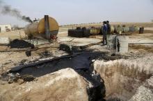 Men work at a makeshift oil refinery site in Marchmarin town, southern countryside of Idlib, Syria in this December 16, 2015, file photo. PHOTO BY REUTERS/Khalil Ashawi