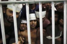 Men claiming to be from Bangladesh react from inside a communal cell at Songkhla Immigration Detention Centre (IDC), where they are kept with some Myanmar Rohingya people also rescued from human traffickers near Thailand's border with Malaysia, February 12, 2014. PHOTO BY REUTERS/Damir Sagolj