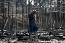 A migrant stands among the remains of a burned tent at the Moria migrant camp, after a fire that ripped through tents and destroyed containers during violence among residents, on the island of Lesbos, Greece, September 20, 2016. PHOTO BY REUTERS/Giorgos Moutafis